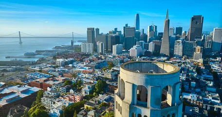 Poster Aerial of roof of Coit Tower overlooking downtown skyscrapers and Oakland Bay Bridge © Nicholas J. Klein