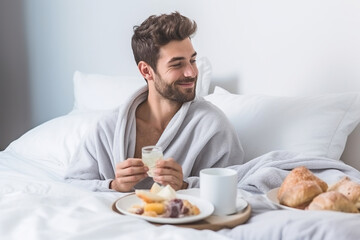 Young gay man eating breakfast in bed - obrazy, fototapety, plakaty