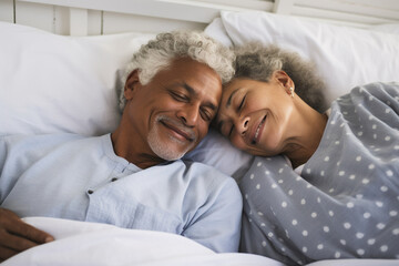 Happy senior couple lying in bed and embracing at home