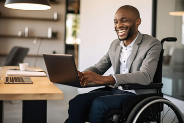 Smiling African American businessman with disability using laptop in wheelchair - obrazy, fototapety, plakaty