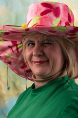 Clown in a hat. The buffoon grimaces and entertains. Portrait of a dressed up artist.