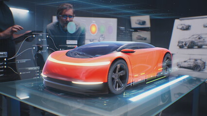 Two male automotive designers create design of eco-friendly electric car, choose color using tablet...