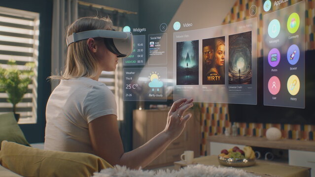 Woman in augmented reality headset chooses movie or TV show to watch at home. 3D graphics shows interface of streaming service app and widgets in user menu. VFX animation. Entertainment and lifestyle.