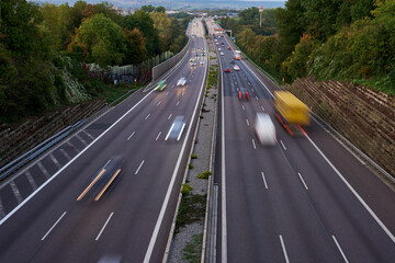Night lights from car headlights on roundabout in night city. Traces of headlights on the road at night, long exposure. Drone aerial shot. Panoramic aerial view of illuminated road overpass and road