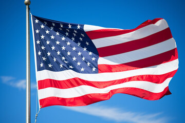 Obraz premium The American flag waving proudly against a clear blue sky