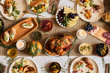 Top view background of cozy dinner table set for Thanksgiving with delicious roasted turkey and comfort food, copy space - obrazy, fototapety, plakaty
