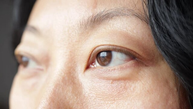 Laser eye surgery. Close up macro shot of Asian female eyes looking aside advertising contact lenses ophthalmology clinic services procedures for good eyesight. Focus on left eye on model face