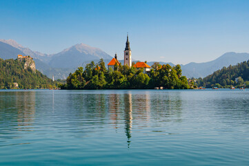 View of Lake Bled with St. Marys Church of Assumption on a small island on a sunny day. Lake with...