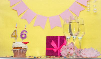 Date of birth with number 46. Festive pudding pie with a candle. Happy birthday decorations for a...