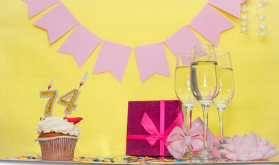 Date of birth with number 74. Festive pudding pie with a candle. Happy birthday decorations for a...