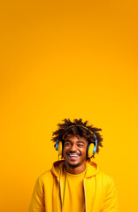 Young man in 90s style clothing wearing a headset looking stylish and funky. Fashion style photograph in a colorful 1990ies style. Yellow Studio background with copy space.