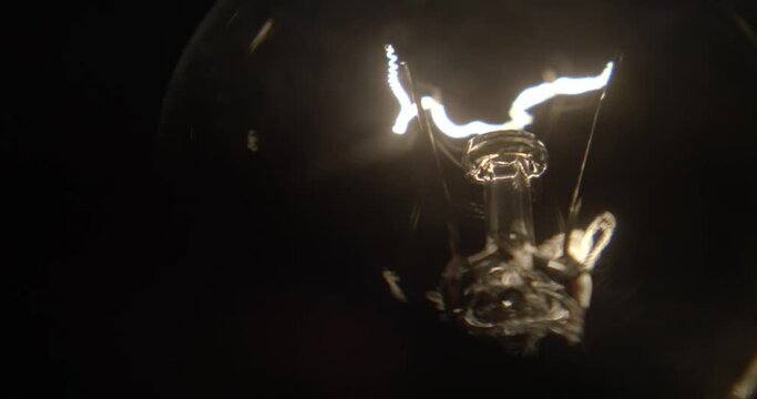 Close up of a lightbulb on a black background with copy space