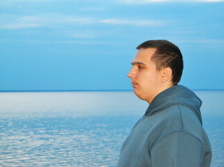 A young autistic guy on an evening walk by the lake