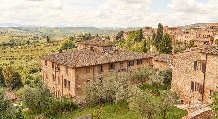 Fototapeta na wymiar Typical house of the medieval city of San Gimignano surrounded by the Tuscan countryside 