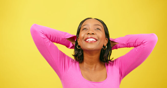 Beautiful woman puts arms behind head, relaxation stretch, yellow studio