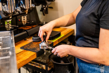 crop of the hands of a professional barista preparing a coffee in a cup inside a specialty coffee