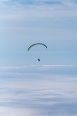 paragliding in the blue sky above the clouds