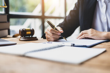 Lawyer working on paperwork in the office. Female lawyer reading contract agreement documents...