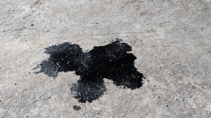 Abstract black engine oil drop on concrete floor texture backgruond.
Automobile garage dirty old oil stain cement pattern.  