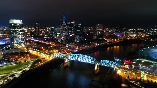 Aerial Panning Shot Of Illuminated Bridge Over Cumberland River In City Against Sky - Nashville, Tennessee