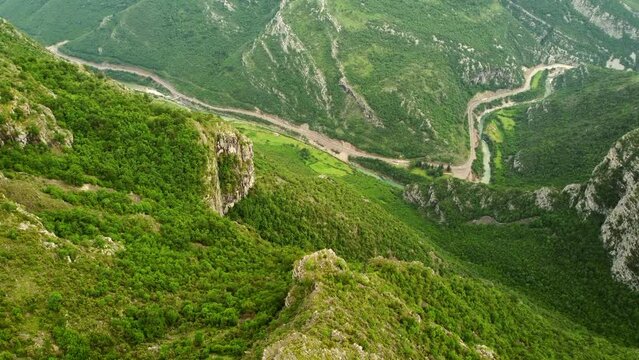 Panoramic aerial scenic drone view to the mountains and the highway and mountain river in the valley. Mountain landscape near Delaj village and aerial view of the border between Montenegro and Albania