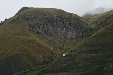 Georgia, Kazbegi region. View of green and rocky peaks of mountains and cloudy sky from Truso...