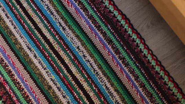 Knitted background, knitted fabric, knitted texture. Soft material. Handmade carpet closeup photo. Cozy background. Knitted details.