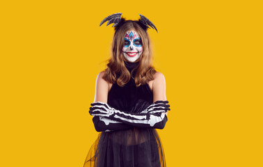 Portrait of funny teenager in Halloween costume on isolated yellow background. Smiling girl in...