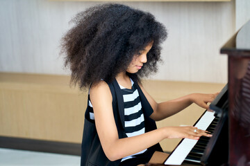 Smile girl practice play piano for up skill of music ability for future occupation.