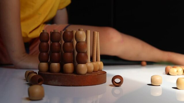 logic wooden board game and a boy playing with it close-up