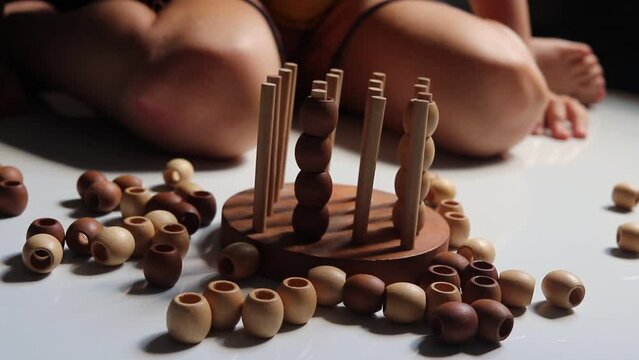 logic wooden board game and a boy playing with it close-up