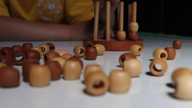 logic wooden board game and a boy playing with it close-up