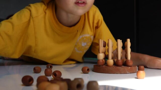 logic wooden board game and a boy playing with it close-up