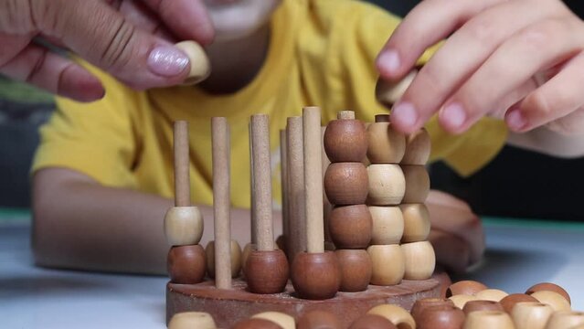 logic wooden board game and a boy playing with it close-up