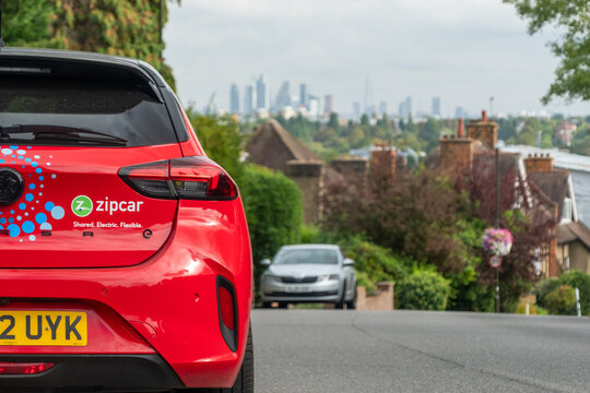 LONDON- September 12, 2023: Zipcar parked on street with London skyline in the background- UK&rsquo;s largest car sharing club