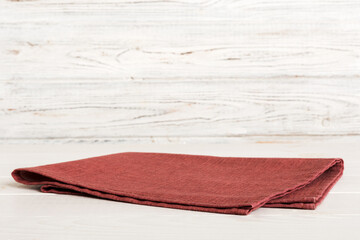 top view with red empty kitchen napkin isolated on table background. Folded cloth for mockup with copy space, Flat lay. Minimal style - obrazy, fototapety, plakaty