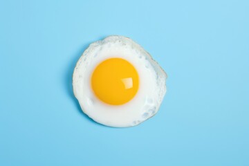 One fried egg isolated on blue background, top view