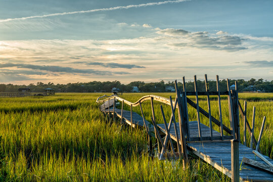 old dilapidated wooden dock in the marshgrass and inlet of Palweys Island in South Carolina