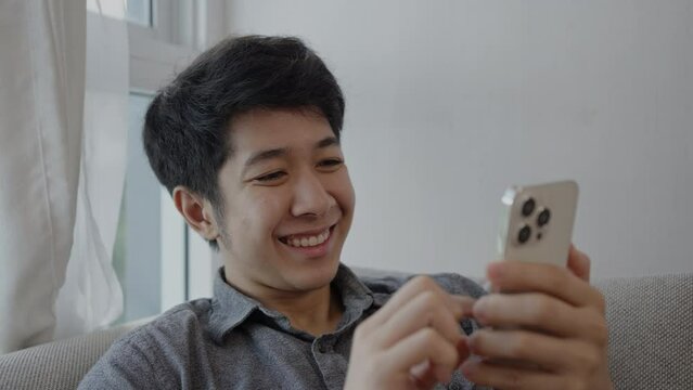 Man Laughs Happily at Humorous Video on Mobile, Enjoying a Good Laugh While Watching Funny Clip on Smartphone.
