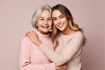 light smile elder parent mom with young adult daughter in studio on plain background
