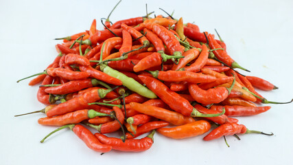 Big pile of chiili peppers in different colors, yellow, green and red, isolated on white