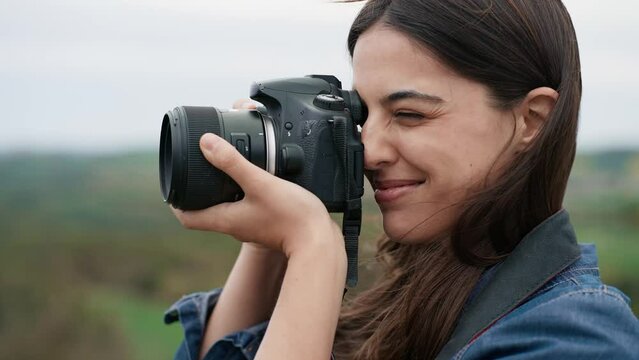 Video of  cheerful woman photographer taking pictures in the beautiful mountain landscape