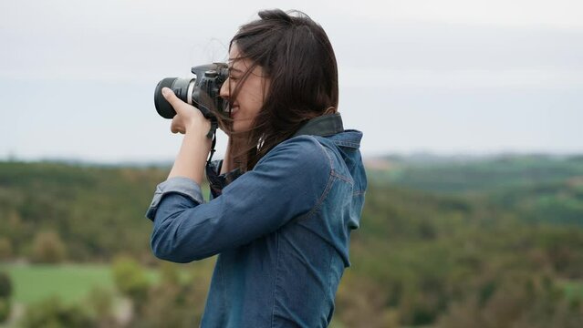 Video of  pretty woman photographer taking pictures in the beautiful mountain landscape