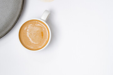 Cup of cappuccino coffee on a plain white table background. Cozy flatlay and top view. Coffee mug...
