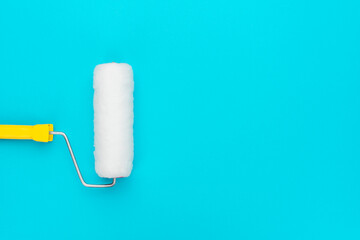 Obraz premium Clean paint roller on the turquoise blue background with copy space