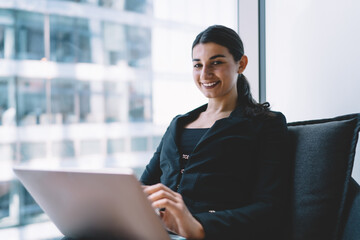 Smiling woman working on netbook in office