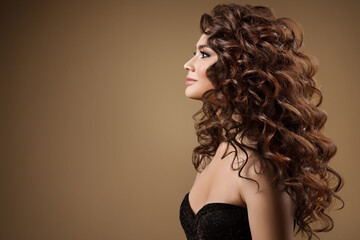 Beauty Model with Long Curly Hairstyle side view. Fashion Woman with Smooth Wavy Brown Hair....