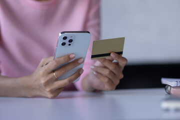 Women holding credit card and using smartphones at home.Online shopping, internet banking, store online, payment, spending money, e-commerce payment at the store, credit card, concept

