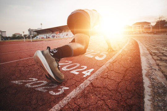Athletes who start running on a rubber track with a bright sunset, blurred background. Ideas for starting something new, starting a new thing, starting a successful one, leading an organization	