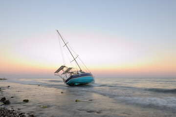velero encallado en una playa de Marbella al atardecer
